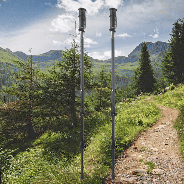 A pair of Pepper Poles stand upright on a scenic hiking trail surrounded by lush greenery and rolling mountain peaks. The poles are black, adjustable, and designed with ergonomic handles that discreetly conceal built-in pepper spray for personal safety. The animation showcases the functionality of the poles, highlighting their innovative safety feature. The bright sky and winding dirt path invite outdoor adventure, emphasizing the balance between exploration and security that Pepper Poles provide.